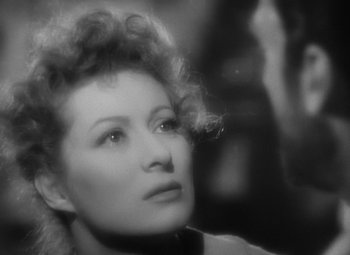 Movie still from “Madame Curie” (1943), directed by Mervyn LeRoy – An old black and white photo of a woman looking to her left; Close Up shot, Over the shoulder angle