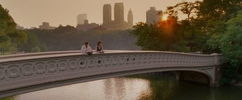 Movie still from “Made of Honor” (2008), directed by Paul Weiland – Two people sitting on a bridge near a body of water; Wide shot, High angle