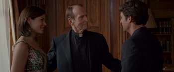 Movie still from “Made of Honor” (2008), directed by Paul Weiland – Two men in suits talking to each other in front of a wooden door; Medium shot, Over the shoulder angle