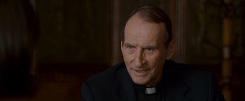 Movie still from “Made of Honor” (2008), directed by Paul Weiland – An older man wearing a priest's outfit; Close Up shot, Over the shoulder angle