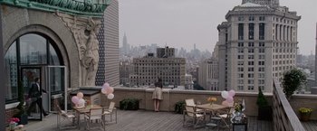 A woman standing on a balcony looking out at a city