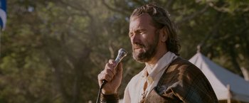 Movie still from “Made of Honor” (2008), directed by Paul Weiland – A man with long hair and a beard holding a microphone; Close Up shot, Low angle