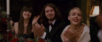 Movie still from “Made of Honor” (2008), directed by Paul Weiland – A man with long hair clapping in front of two other people; Medium shot, Over the shoulder angle