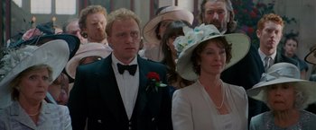 Movie still from “Made of Honor” (2008), directed by Paul Weiland – A group of people standing next to each other in formal wear; Medium shot, Over the shoulder angle