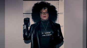 Movie still from “Madea Goes to Jail” (2009), directed by Tyler Perry – A man in a black leather jacket and a black shirt with a black wig on his head; Medium shot, Low angle
