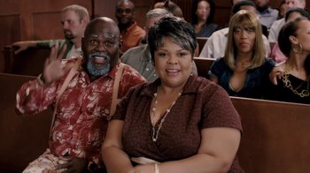 Movie still from “Madea Goes to Jail” (2009), directed by Tyler Perry – A man and a woman sitting in front of a crowd; Medium shot, High angle