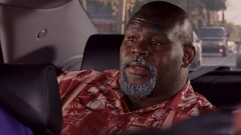 Movie still from “Madea Goes to Jail” (2009), directed by Tyler Perry – A man with a beard and a red shirt is sitting in a car; Close Up shot, High angle