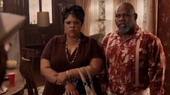 Movie still from “Madea Goes to Jail” (2009), directed by Tyler Perry – A man and a woman standing next to each other in a living room; Medium shot, High angle