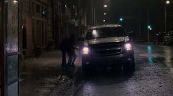Movie still from “Madea Goes to Jail” (2009), directed by Tyler Perry – Two people standing on the side of the road next to a parked car; Wide shot, High angle