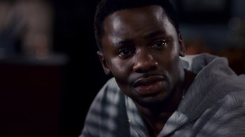 Movie still from “Madea Goes to Jail” (2009), directed by Tyler Perry – A person sitting down with his eyes wide open; Close Up shot, High angle