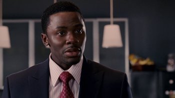 Movie still from “Madea Goes to Jail” (2009), directed by Tyler Perry – A man wearing a suit and tie in front of a wall; Close Up shot, High angle