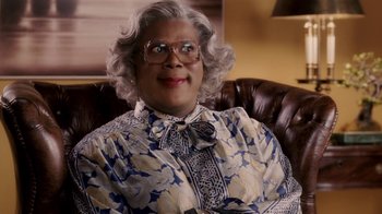 Movie still from “Madea Goes to Jail” (2009), directed by Tyler Perry – A person sitting in a chair wearing glasses; Close Up shot, High angle