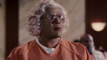 Movie still from “Madea Goes to Jail” (2009), directed by Tyler Perry – A man with a blonde wig and glasses; Close Up shot, Low angle