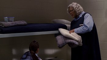 Movie still from “Madea Goes to Jail” (2009), directed by Tyler Perry – A woman is holding a pillow while standing next to a girl; Medium shot, High angle