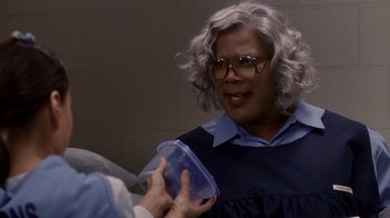 Movie still from “Madea Goes to Jail” (2009), directed by Tyler Perry – A woman holding a container in her hands; Close Up shot, Over the shoulder angle