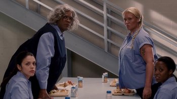 Movie still from “Madea Goes to Jail” (2009), directed by Tyler Perry – A man and a woman sitting at a table with plates of food; Medium shot, Low angle