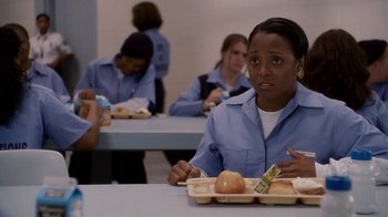 Movie still from “Madea Goes to Jail” (2009), directed by Tyler Perry – A woman sitting at a table with a tray of food; Medium shot, High angle