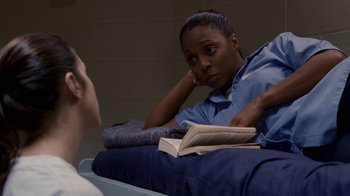 Movie still from “Madea Goes to Jail” (2009), directed by Tyler Perry – A woman sitting on a bed reading a book; Medium shot, Over the shoulder angle