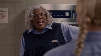 Movie still from “Madea Goes to Jail” (2009), directed by Tyler Perry – A woman in a blue shirt is talking to someone; Medium shot, Over the shoulder angle
