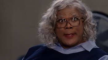 Movie still from “Madea Goes to Jail” (2009), directed by Tyler Perry – A person wearing glasses and a wig; Close Up shot, High angle
