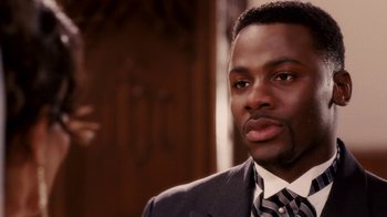 Movie still from “Madea Goes to Jail” (2009), directed by Tyler Perry – A person wearing a suit and tie; Close Up shot, Over the shoulder angle