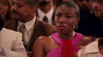 Movie still from “Madea Goes to Jail” (2009), directed by Tyler Perry – A woman in a pink and red dress sitting next to a man in a brown suit; Close Up shot, Over the shoulder angle