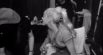 Movie still from “Madonna: Truth or Dare” (1991), directed by Alek Keshishian – A woman with long blonde hair is sitting down; Close Up shot, High angle