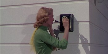 Movie still from “Magnificent Obsession” (1954), directed by Douglas Sirk – A woman is holding a remote control on a wall; Close Up shot, Low angle