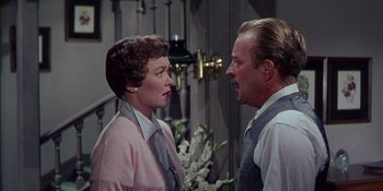 Movie still from “Magnificent Obsession” (1954), directed by Douglas Sirk – An older man and a younger woman are talking to each other; Medium shot, Over the shoulder angle