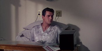 Movie still from “Magnificent Obsession” (1954), directed by Douglas Sirk – A man sitting in a bed looking at the camera; Medium shot, High angle