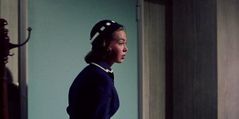 Movie still from “Magnificent Obsession” (1954), directed by Douglas Sirk – A woman wearing a blue jacket and a white hat; Medium shot, Low angle