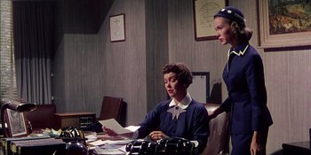 Movie still from “Magnificent Obsession” (1954), directed by Douglas Sirk – Two women are sitting at a desk in an office; Medium shot, Low angle