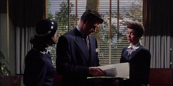 Movie still from “Magnificent Obsession” (1954), directed by Douglas Sirk – A group of people standing next to each other in a room; Medium shot, Low angle