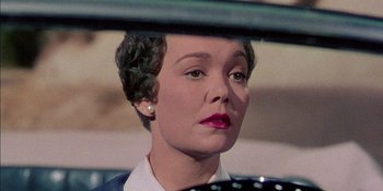 Movie still from “Magnificent Obsession” (1954), directed by Douglas Sirk – A person sitting in a car; Close Up shot, Over the shoulder angle