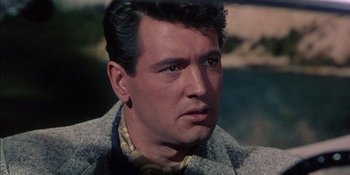 Movie still from “Magnificent Obsession” (1954), directed by Douglas Sirk – A person wearing a suit and tie; Close Up shot, Over the shoulder angle