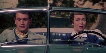 Movie still from “Magnificent Obsession” (1954), directed by Douglas Sirk – A man and a woman sitting in the back seat of a car; Medium shot, Low angle