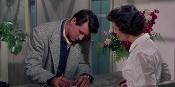 Movie still from “Magnificent Obsession” (1954), directed by Douglas Sirk – A man and a woman sitting at a table with flowers; Medium shot, High angle