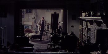Movie still from “Magnificent Obsession” (1954), directed by Douglas Sirk – A man standing in front of an easel in a room; Wide shot, High angle