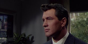 Movie still from “Magnificent Obsession” (1954), directed by Douglas Sirk – A person wearing a suit and tie; Close Up shot, Low angle