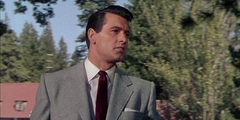 Movie still from “Magnificent Obsession” (1954), directed by Douglas Sirk – A person wearing a suit and tie; Close Up shot, Low angle