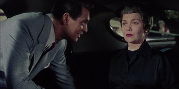 Movie still from “Magnificent Obsession” (1954), directed by Douglas Sirk – A man and a woman sitting in a car looking at each other; Medium shot, Over the shoulder angle