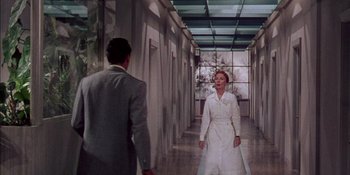 Movie still from “Magnificent Obsession” (1954), directed by Douglas Sirk – A man and a woman walking down a hall way; Wide shot, Low angle