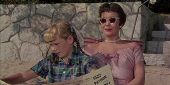 Movie still from “Magnificent Obsession” (1954), directed by Douglas Sirk – A woman and a girl sitting next to each other; Medium shot, Low angle
