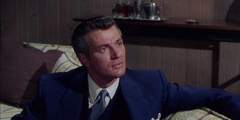 Movie still from “Magnificent Obsession” (1954), directed by Douglas Sirk – A person wearing a suit and tie; Close Up shot, Over the shoulder angle