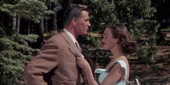Movie still from “Magnificent Obsession” (1954), directed by Douglas Sirk – A man and a woman standing next to each other in front of trees; Medium shot, Over the shoulder angle