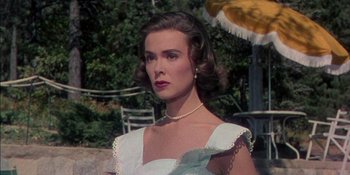 Movie still from “Magnificent Obsession” (1954), directed by Douglas Sirk – A woman in a white dress with a necklace; Close Up shot, Low angle