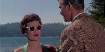 Movie still from “Magnificent Obsession” (1954), directed by Douglas Sirk – A man and a woman wearing sunglasses near a body of water; Close Up shot, Over the shoulder angle