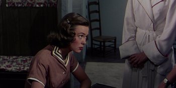 Movie still from “Magnificent Obsession” (1954), directed by Douglas Sirk – A woman in a brown shirt looking at a person; Medium shot, Over the shoulder angle