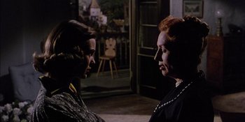 Movie still from “Magnificent Obsession” (1954), directed by Douglas Sirk – Two women are talking in the dark; Medium shot, Over the shoulder angle