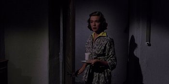 Movie still from “Magnificent Obsession” (1954), directed by Douglas Sirk – A woman holding a plate and a cup in her hand; Medium shot, High angle